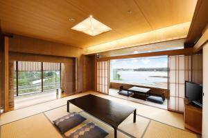 Kikusuitei في توكوروزاوا: غرفة معيشة مع طاولة وتلفزيون
