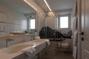 La salle de bains est pourvue d'une baignoire, d'un lavabo et de toilettes. dans l'établissement Romantik Residenz (Ferienwohnungen Hotel Im Weissen Rössl) - Dependance, à Sankt Wolfgang im Salzkammergut