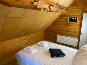 a bedroom with a bed with two towels on it at BESSO Log Cabin Niseko in Niseko