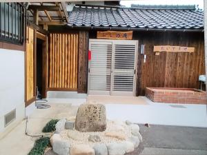 a house with a stone statue in front of it at ゲストハウス ふしの庵 in Ogori +8 photos