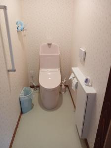 a small bathroom with a toilet and a trash can at ゲストハウス ふしの庵 in Ogori