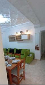 sala de estar con mesa y sofá verde en City apartment en Valencia