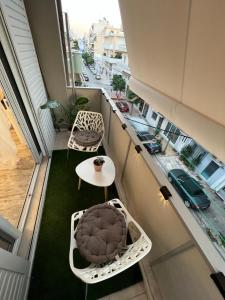 a balcony with a table and chairs and a street at Selenity studio(close to two metro stations) in Piraeus