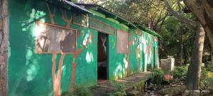 a green building with graffiti on the side of it at Hostel La Gloria in Ometepe
