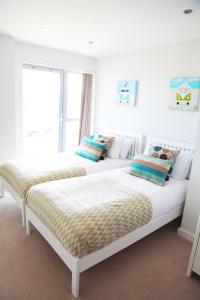 Duas camas sentadas uma ao lado da outra num quarto em Azure 7 Apartment em Newquay
