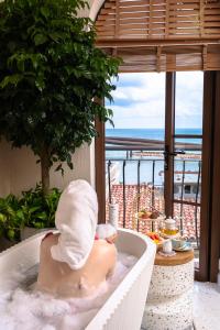 un hombre en una bañera con una toalla en Roma Hotel Phu Quoc - Free Hon Thom Island Waterpark Cable Car en Phu Quoc