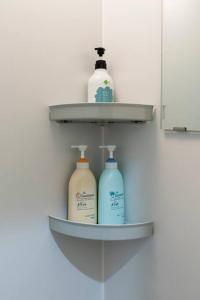 a shelf with three bottles of detergent on a wall at Sprinkle inn in Sapporo
