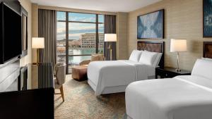 a hotel room with two beds and a flat screen tv at The Westin Huntsville in Huntsville