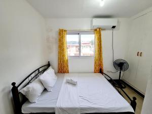 a bed in a small room with a window at Calapan Transient Maple L82 in Calapan