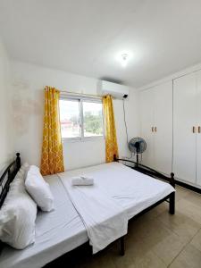 a large bed in a room with a window at Calapan Transient Maple L82 in Calapan
