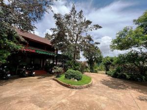 a house with a bush in front of a building at SORA HOMESTAY in Pleiku