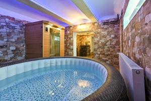 jacuzzi w pokoju z kamienną ścianą w obiekcie Holiday Home Lu w mieście Grkavešćak