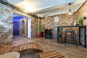 a room with a stone wall and a bar with a stool at Holiday Home Lu in Grkavešćak