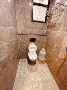 a small bathroom with a toilet in a stall at White House - A Four Star Luxury Resort in Haridwār