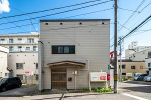 a building with a large door on a street at YADOt Inn OTARU in Otaru