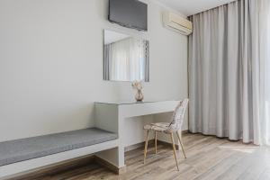 Habitación blanca con escritorio y silla en Sunrise Zante - Adults Only Hotel en Tsilivi