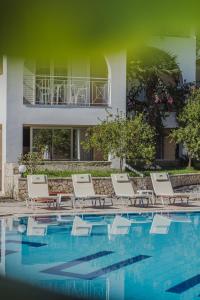 a group of lounge chairs next to a swimming pool at Sunrise Zante - Adults Only Hotel in Tsilivi