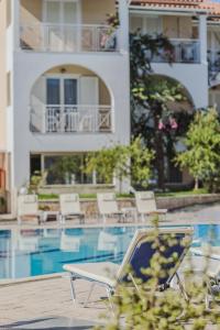 a chaise lounge chair next to a swimming pool at Sunrise Zante - Adults Only Hotel in Tsilivi