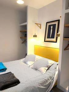a bedroom with a bed with a yellow headboard at Tolila Sidi Bou Said, grande terrasse avec vue in Sidi Bou Saïd