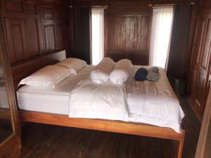 a large bed with white sheets and pillows on it at Casa Ines Bedugul in Gitgit