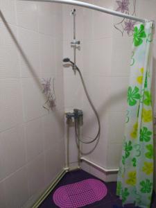 a bathroom with a shower with a pink shower curtain at Квартира-студия с видом на море in Ureki