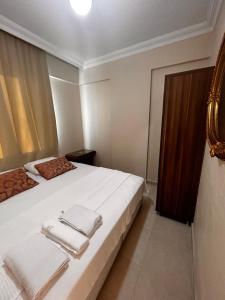 a bedroom with a white bed with towels on it at ELİT APART in Hatay