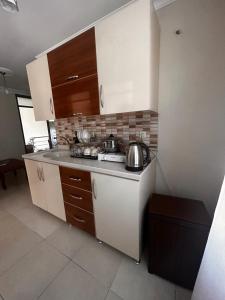 une cuisine avec des placards blancs, des casseroles et des poêles dans l'établissement ELİT APART, à Hatay