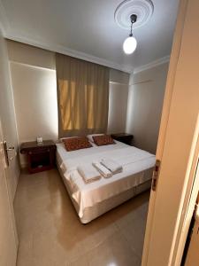 een slaapkamer met een bed met twee handdoeken erop bij ELİT APART in Hatay