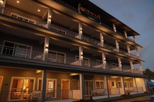 ein Gebäude mit Balkon und Beleuchtung in der Unterkunft Gracias Cafe & Resort in Morjim