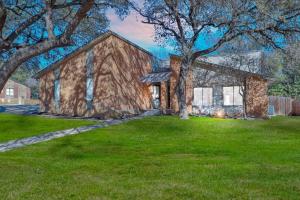 una pintura de una casa de piedra con un árbol en San Antonio Escape, en San Antonio