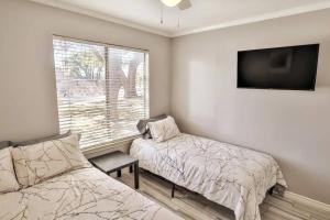 Un dormitorio con una cama y un televisor y una ventana. en San Antonio Escape, en San Antonio 23 fotos más
