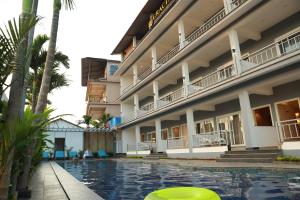 un hotel con piscina frente a un edificio en Gracias Cafe & Resort en Morjim