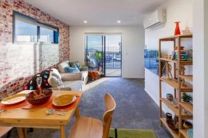 a kitchen and living room with a table and chairs at Okioki - Seaside Escape in Christchurch