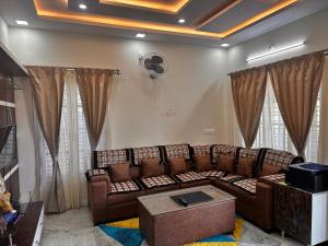 uma sala de estar com um sofá e uma ventoinha em DEEYA Guest House em Maiçor