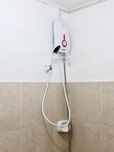 a hair dryer in the corner of a bathroom at Calapan Transient Maple L82 in Calapan