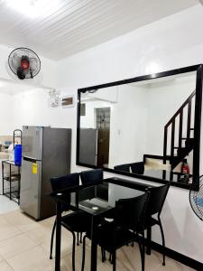 a dining room with a table and chairs and a refrigerator at Calapan Transient Maple L82 in Calapan