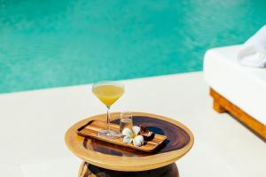 a tray with a glass of wine and flowers on a table at Zazen Boutique Resort & Spa in Bophut