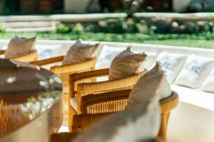a row of wicker chairs with pillows on them at Zazen Boutique Resort & Spa in Bophut