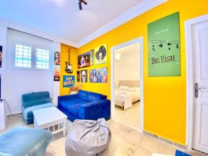 a living room with a blue couch and a yellow wall at S+1 au cœur de la Marsa plage in La Marsa