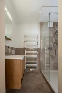 ein Bad mit einer Dusche und einem Waschbecken in der Unterkunft Schwalbennest 1-3 in Juist