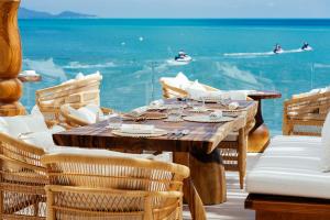 a wooden table and chairs with a view of the ocean at Zazen Boutique Resort & Spa in Bophut