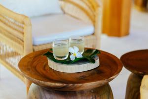 a table with two glasses and a flower on it at Zazen Boutique Resort & Spa in Bophut