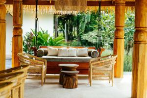 a porch with a couch and two chairs at Zazen Boutique Resort & Spa in Bophut