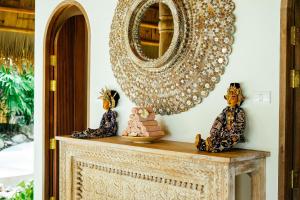 a mirror on top of a table with two statues at Zazen Boutique Resort & Spa in Bophut
