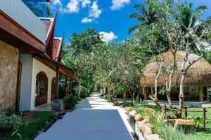 a walkway next to a building with a thatch roof at Zazen Boutique Resort & Spa in Bophut