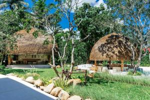 a resort with a grass roofed building with a bench at Zazen Boutique Resort & Spa in Bophut