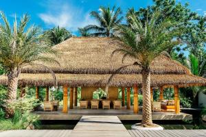 a resort with a thatched roof and palm trees at Zazen Boutique Resort & Spa in Bophut