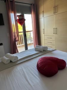 un letto con un cuscino rosso sopra di EVa's Luxury Apartments No 4 a Artemida