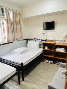 Postel nebo postele na pokoji v ubytování 嘉應賓館HAKKAS GUEST House
