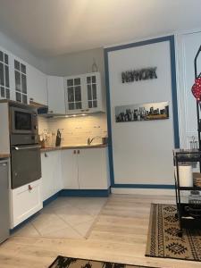 una cocina con armarios blancos y una pared azul en Le Bleu, en Trouville-sur-Mer